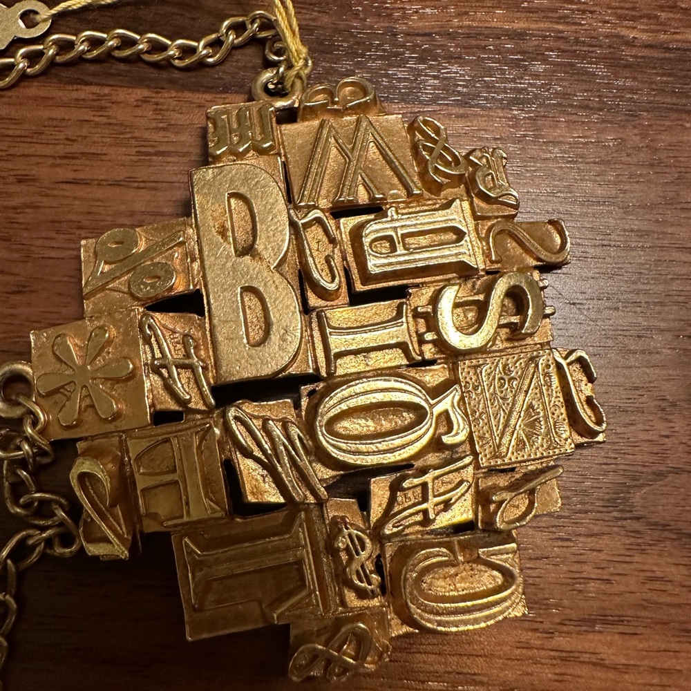 In the style of Puccini Alphabet Stamp Gold Tone pendant necklace